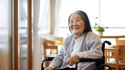 老人ホームで車椅子に乗っている笑顔のおばあちゃん