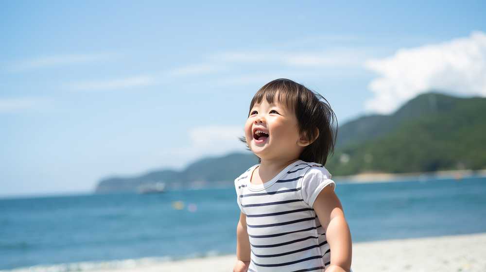 砂浜で笑顔の幼児