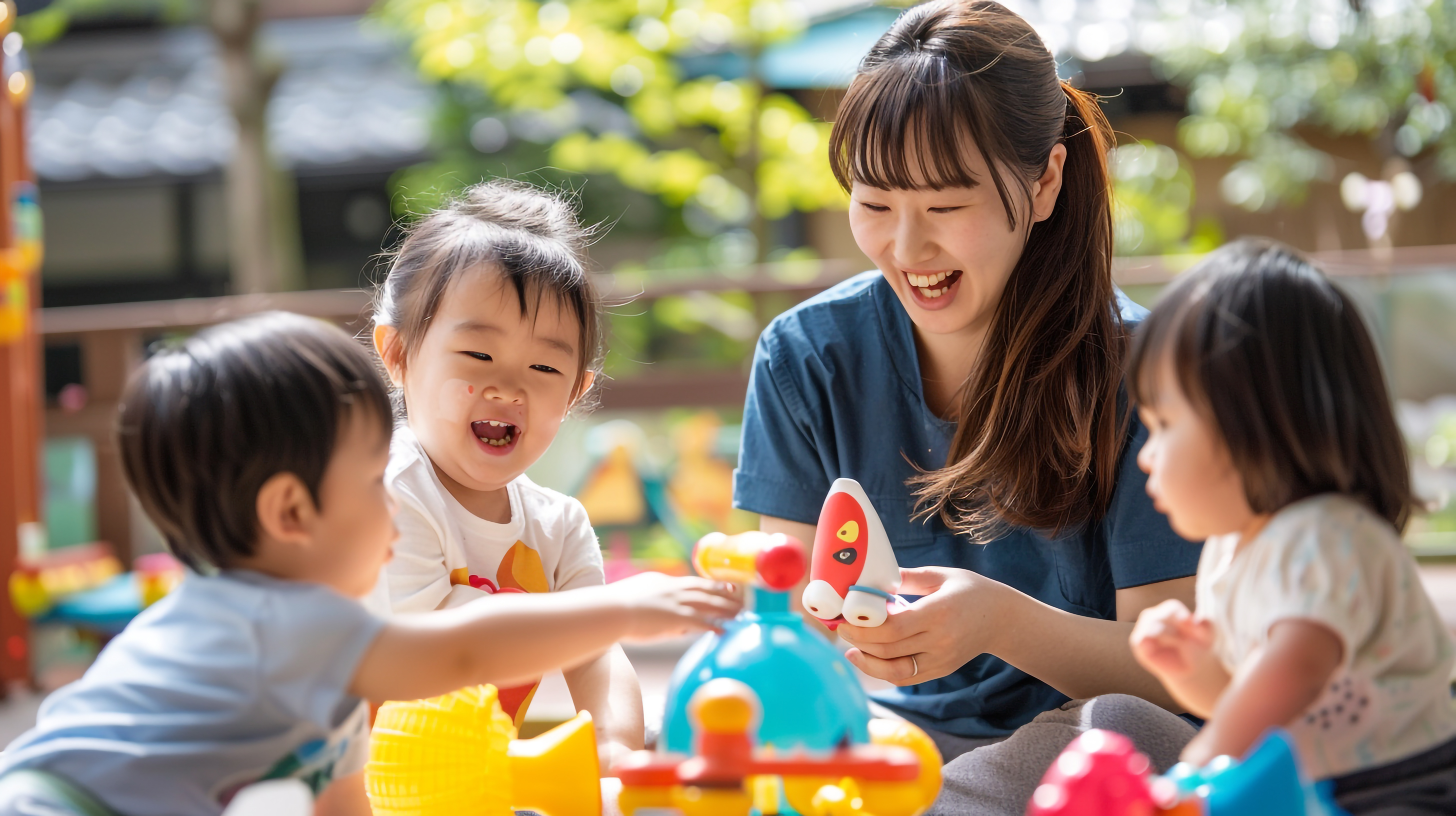 保育士の若い女性と園児たち