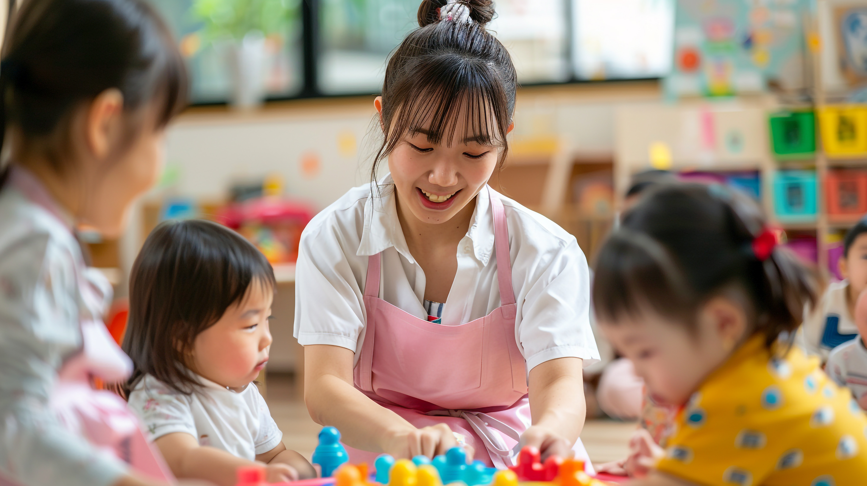 保育士の若い女性と園児たち